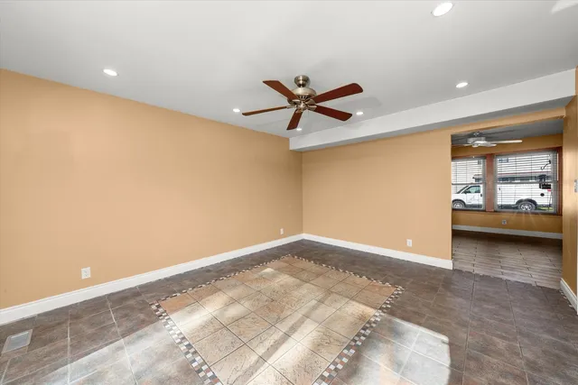 en empty room with a window and a ceiling fan