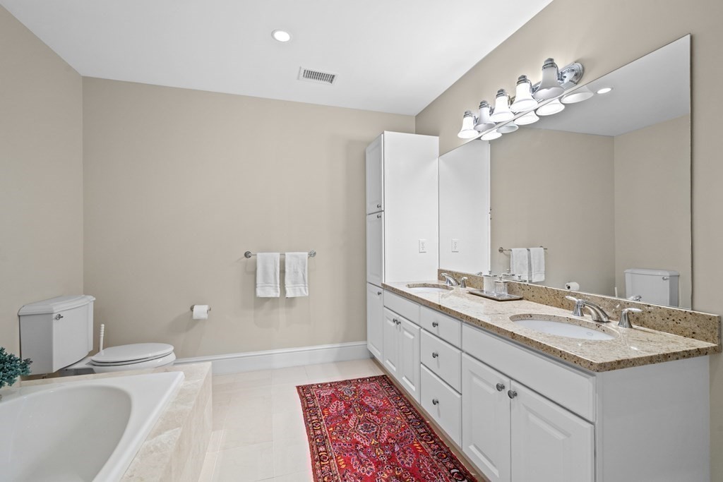 36 Intrepid Circle, Unit 303 Marblehead, MA 01945 - Photo 16 of 22 a spacious bathroom with a granite countertop sink a toilet and a mirror