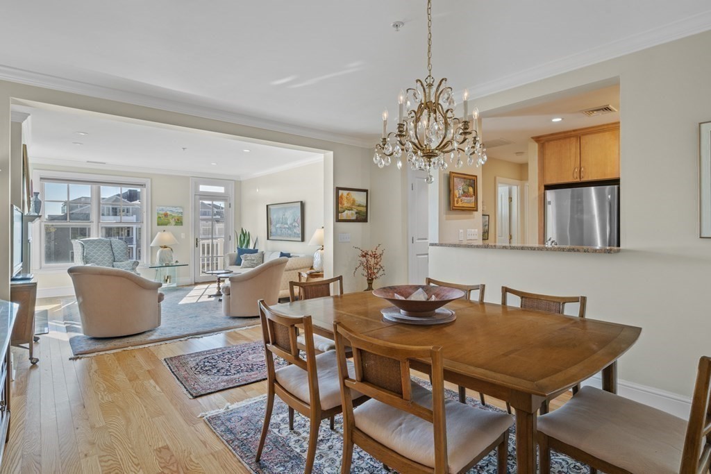 36 Intrepid Circle, Unit 303 Marblehead, MA 01945 - Photo 9 of 22 a dining room with furniture a chandelier and wooden floor