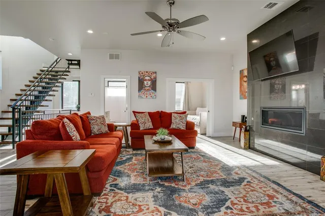 a living room with furniture a flat screen tv and kitchen view