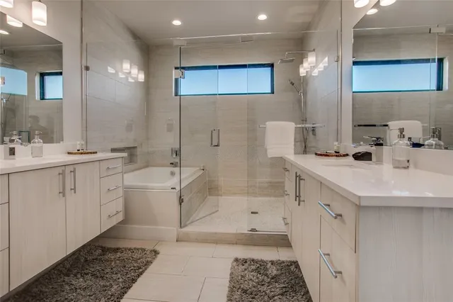 a bathroom with a double vanity sink a mirror and a bathtub