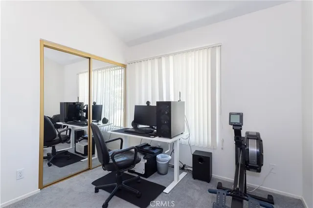 a view of a workspace with furniture and a window