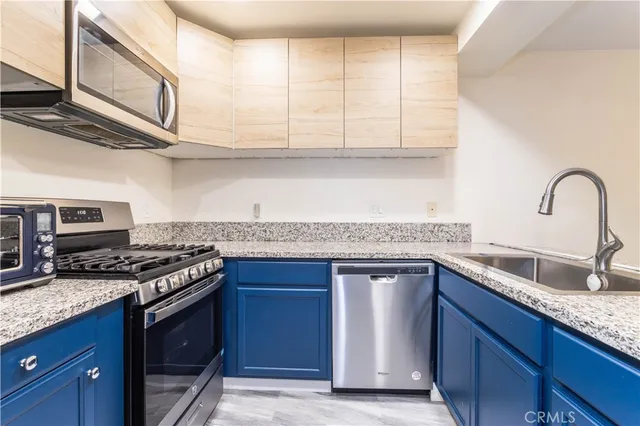 a kitchen with stainless steel appliances granite countertop a sink stove and cabinets