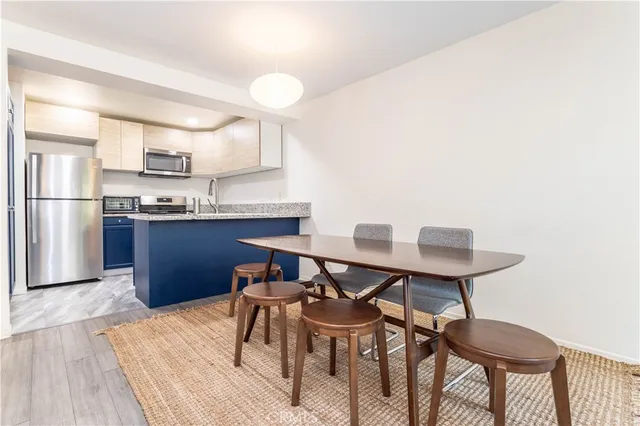 a kitchen with stainless steel appliances kitchen island a table and chairs in it