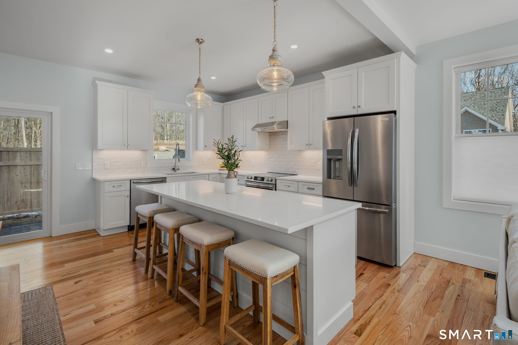 34 Ivy Hill Road, Unit 34 Waterford, CT 06385 - Photo 27 of 36 a kitchen with stainless steel appliances a refrigerator a sink dishwasher a stove a dining table and chairs with wooden floor