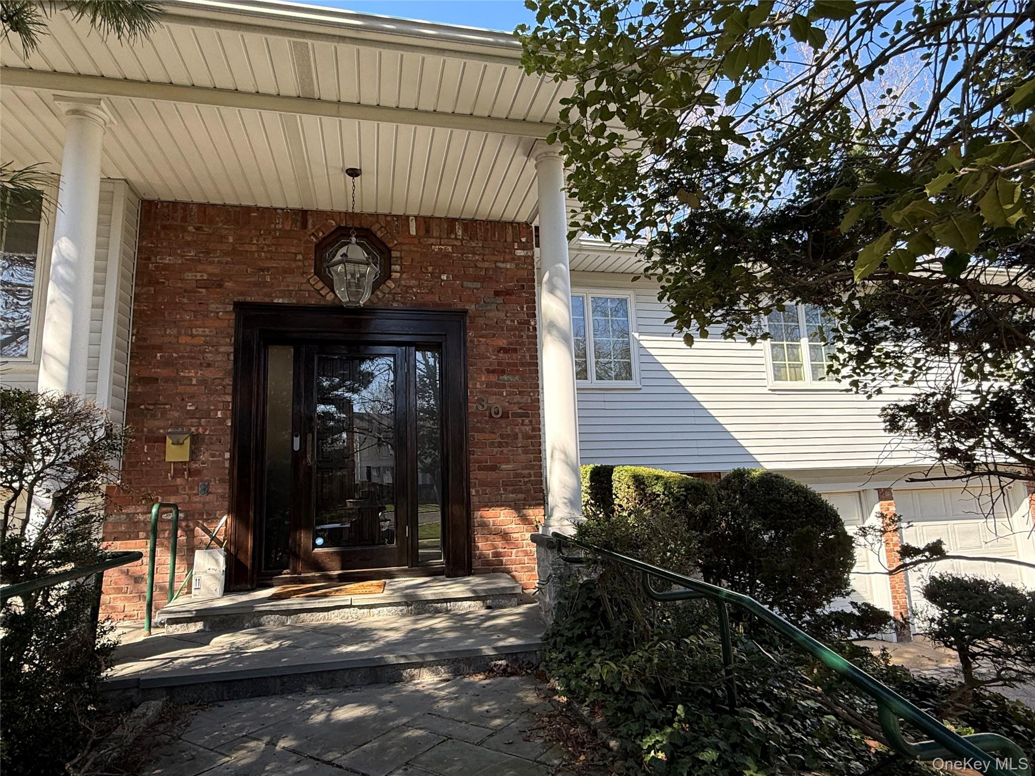 The property features a brick facade with a prominent entryway, supported by white columns
