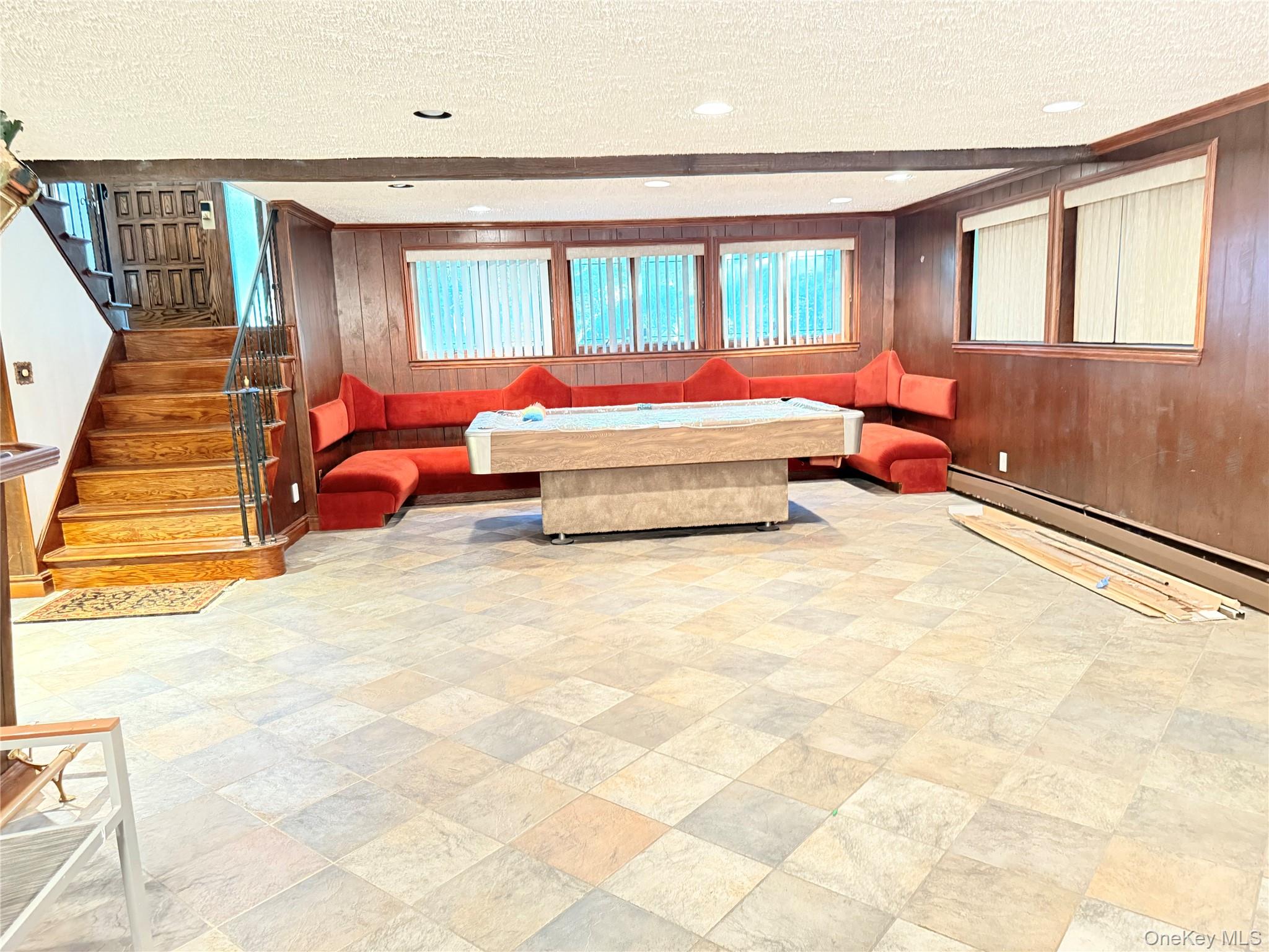 30 Dogwood Road Albertson, NY 11507 - Photo 13 of 20 Spacious recreation room featuring tiled flooring, wood paneling, and an extensive built-in seating area