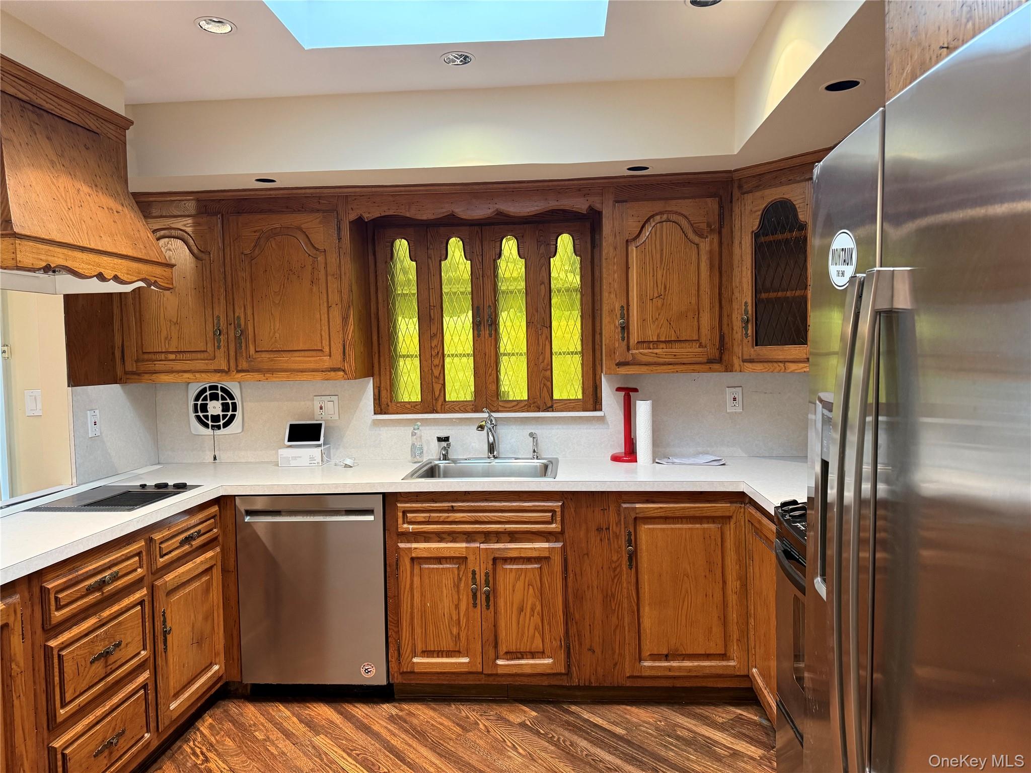 30 Dogwood Road Albertson, NY 11507 - Photo 10 of 20 Kitchen featuring wood cabinetry, stainless steel appliances, white countertops, and a skylight