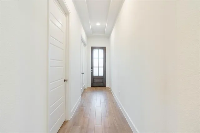 a view of a hallway with wooden floor