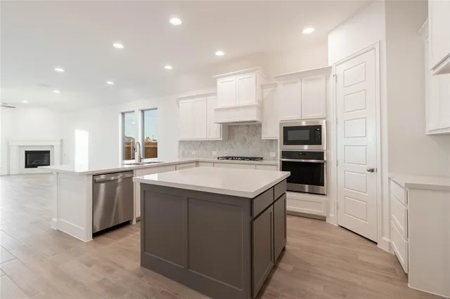 a kitchen with kitchen island sink stove and cabinets