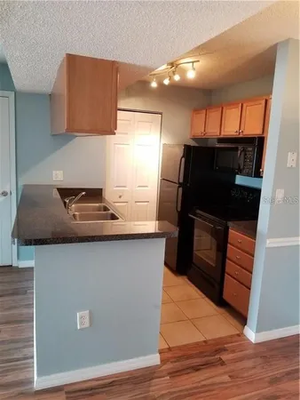 a kitchen with granite countertop a stove and a refrigerator