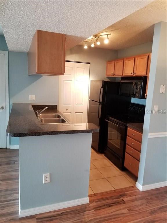 803 Lake Haven Square, Unit 202 Brandon, FL 33511 - Photo 12 of 17 a kitchen with granite countertop a stove and a refrigerator