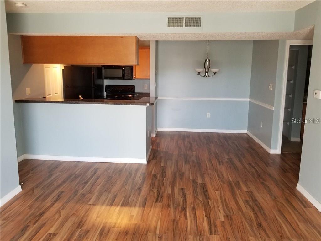 803 Lake Haven Square, Unit 202 Brandon, FL 33511 - Photo 16 of 17 a view of a living room with wooden floor and a ceiling fan