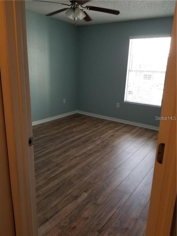 803 Lake Haven Square, Unit 202 Brandon, FL 33511 - Photo 9 of 17 a view of an empty room with wooden floor and a window