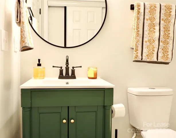 a bathroom with a sink mirror and toilet