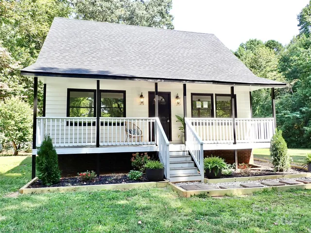 a view of a house with a yard and a garden