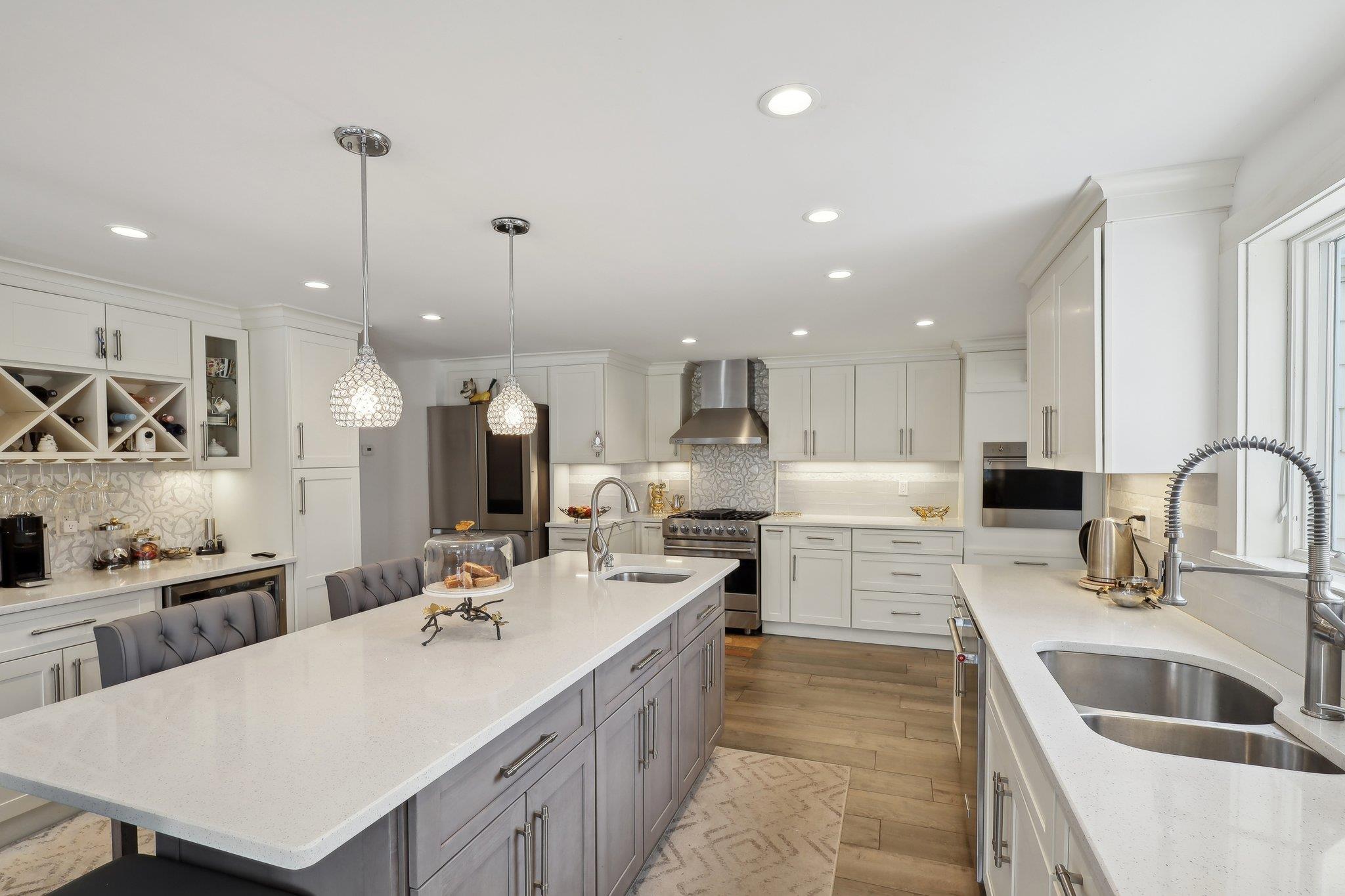 a large kitchen with kitchen island a sink appliances and cabinets