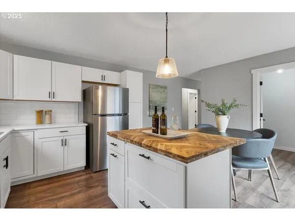 a kitchen with a table chairs refrigerator and cabinets