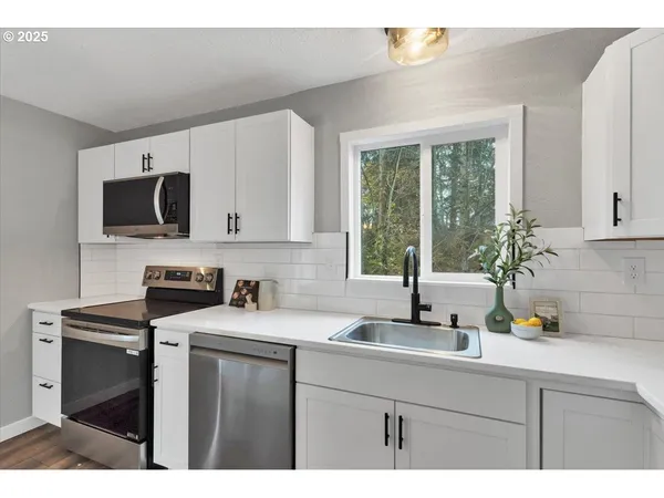 a kitchen with a sink a counter top space cabinets and a window