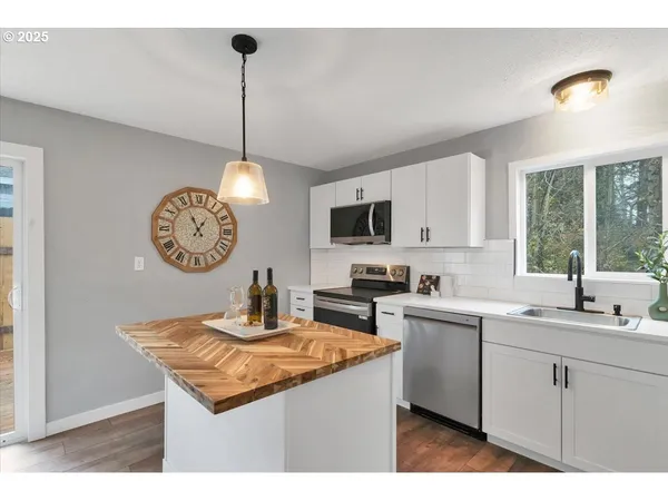 a kitchen with a sink a counter top space cabinets and stainless steel appliances