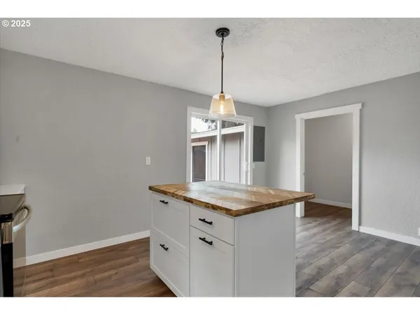 a kitchen with a wooden floor and a chandelier