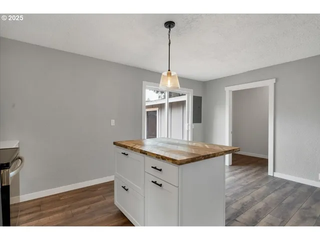 a kitchen with a wooden floor and a chandelier