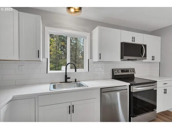 a kitchen with a sink stove and microwave