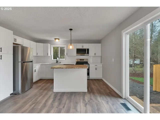 a kitchen with refrigerator cabinets and wooden floor