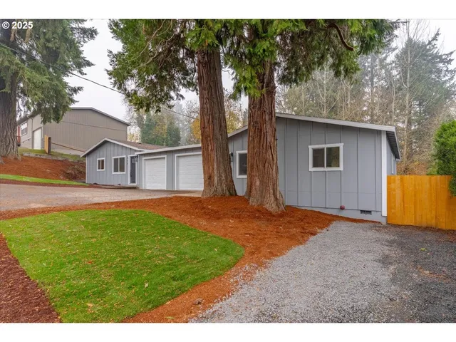 a backyard of a house with barbeque oven and trees