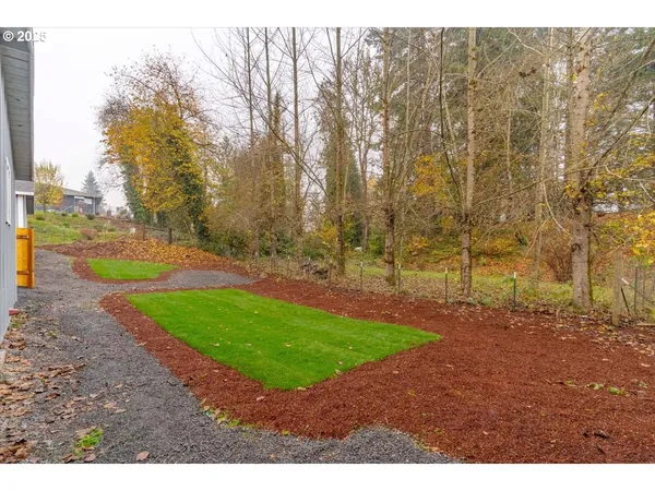 a view of a yard with trees in the background