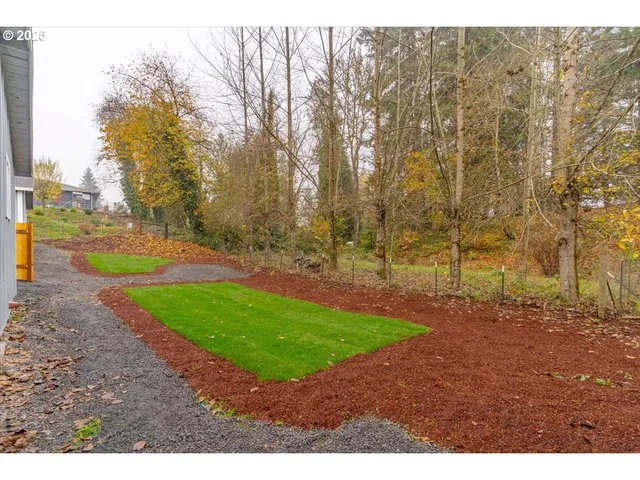 a view of a yard with trees in the background