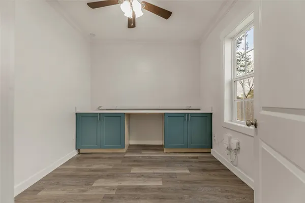 an empty room with windows and cabinet