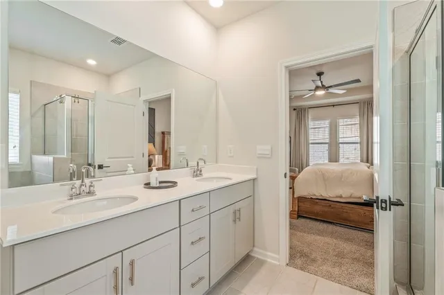 a bathroom with a double vanity sink mirror double and bathtub