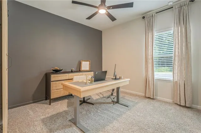 a view of a workspace with furniture and a window