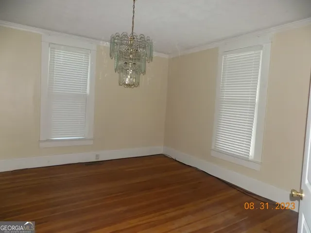 a view of a room with wooden floor and a window