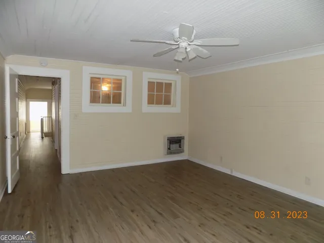 a view of an empty room with wooden floor