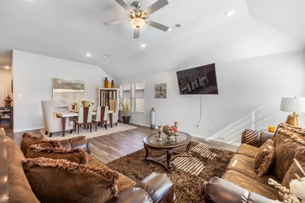 a living room with furniture a flat screen tv and a rug