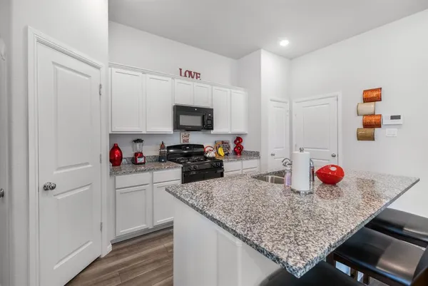 a kitchen with stainless steel appliances granite countertop a sink dishwasher stove refrigerator and cabinets