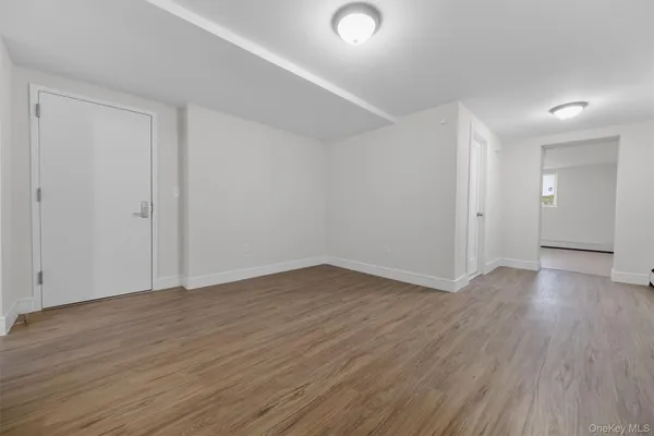 a view of an empty room with wooden floor and closet