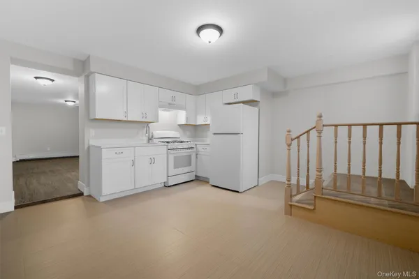 a kitchen with white cabinets and white appliances