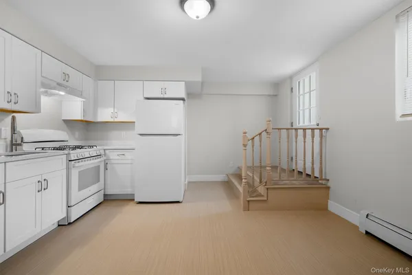 a kitchen with white cabinets and white appliances