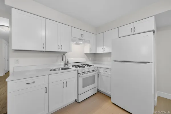 a kitchen with cabinets appliances a sink and a counter top