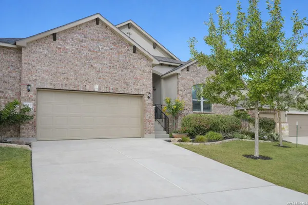 a front view of house with yard and trees around