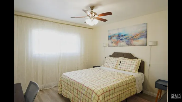 a bedroom with a bed and a painting on the wall