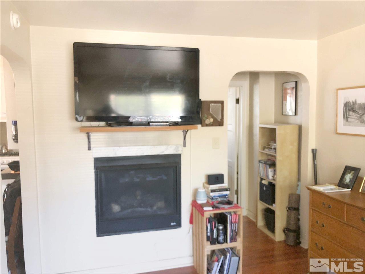 420 Burns Street Reno, NV 89502 - Photo 7 of 17 a living room with a fireplace and a flat screen tv