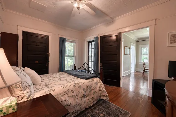 a bedroom with a bed and a dresser with mirror