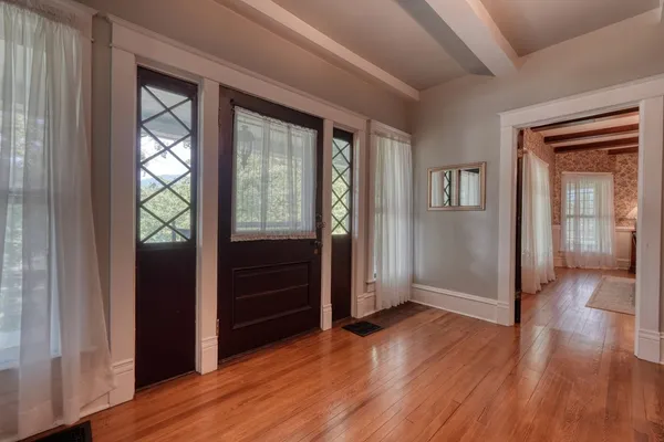 a living room with furniture kitchen view and a wooden floor