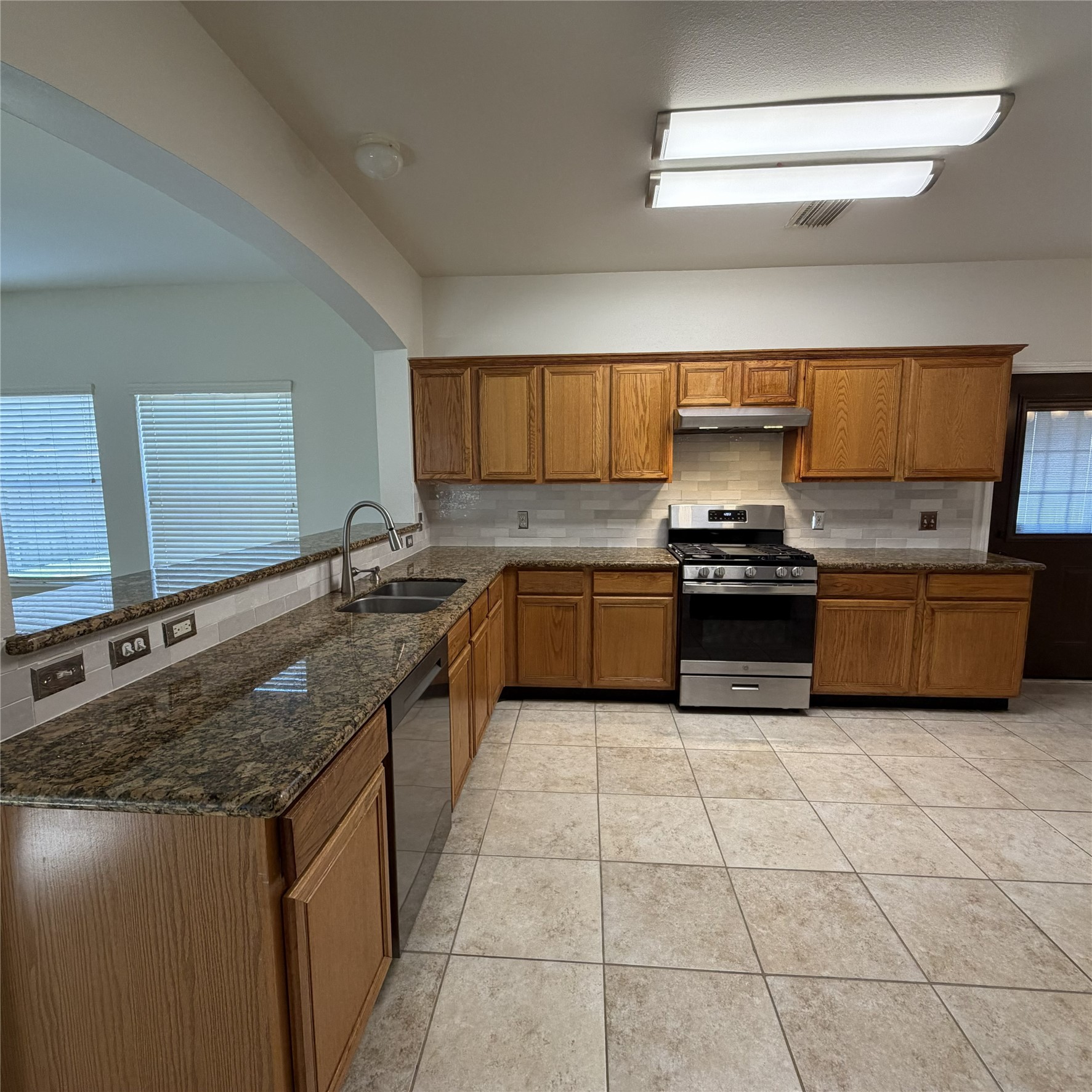 12219 Winderwick Lane Houston, TX 77066 - Photo 14 of 36 a kitchen with stainless steel appliances granite countertop a sink and a stove
