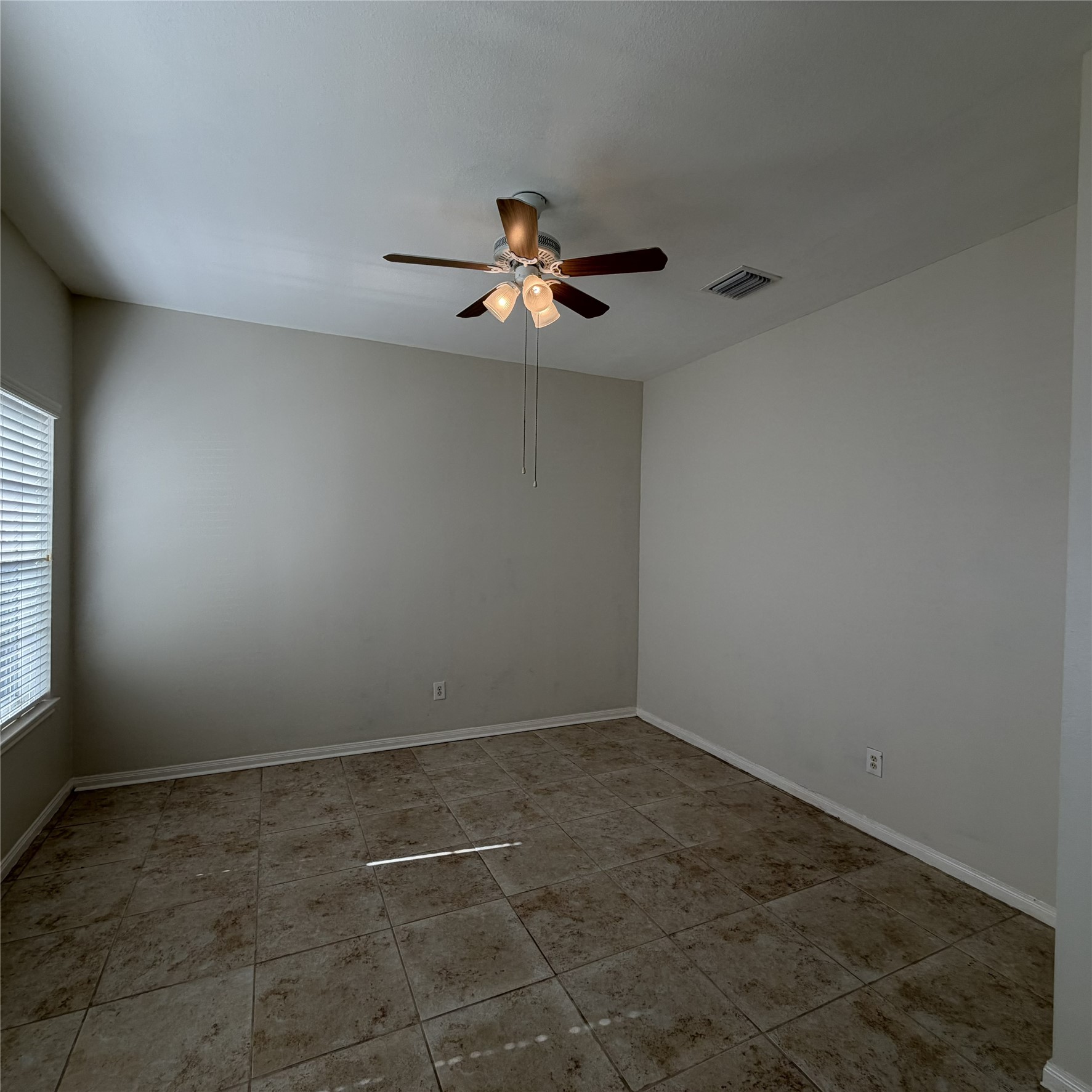 12219 Winderwick Lane Houston, TX 77066 - Photo 8 of 36 an empty room with a window and a ceiling fan