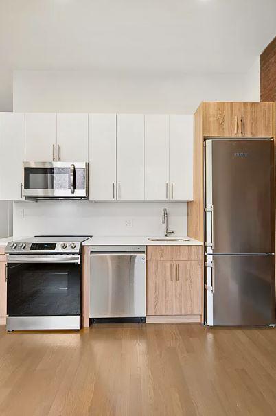 a kitchen with stainless steel appliances a stove a refrigerator and a sink